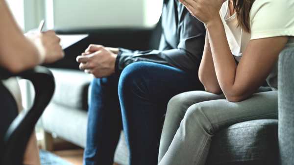 A couple receiving counselling or advice sitting on sofas 