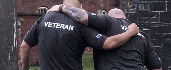 Two veterans hold each other around the shoulders as they walk
